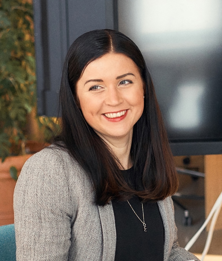 Woman in the Helsinki office smiling at another woman. 