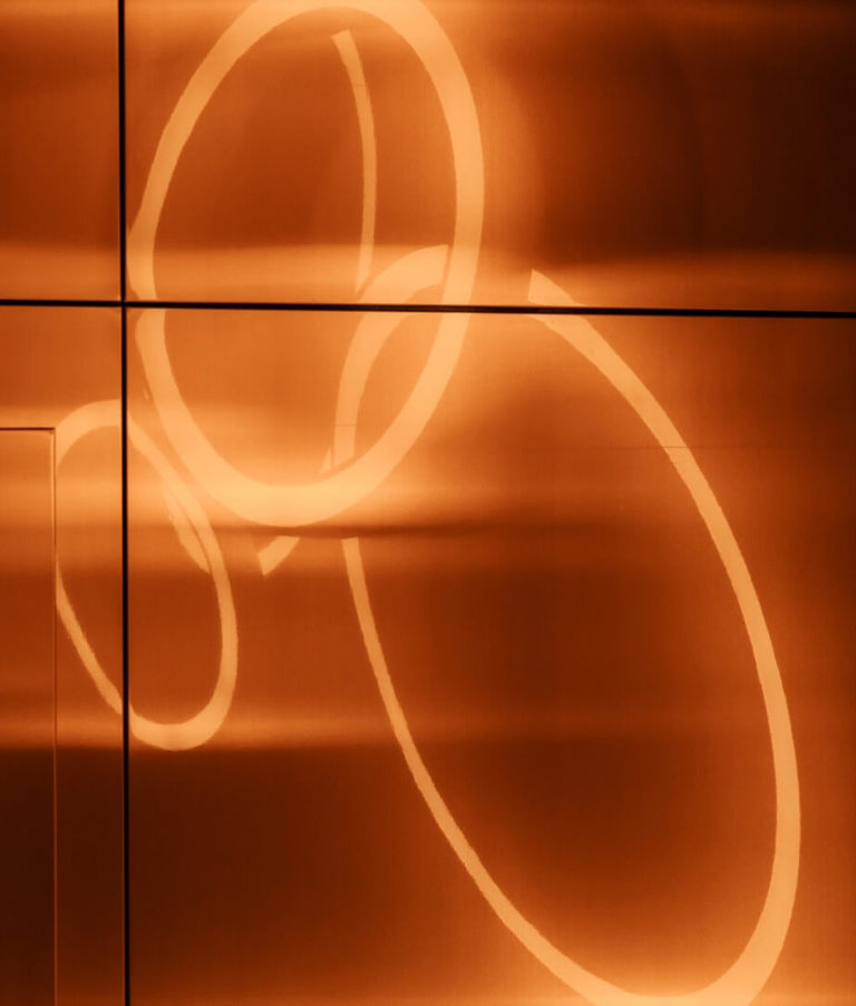 Orange light circles on a wall at the Gdansk Office in Poland. 
