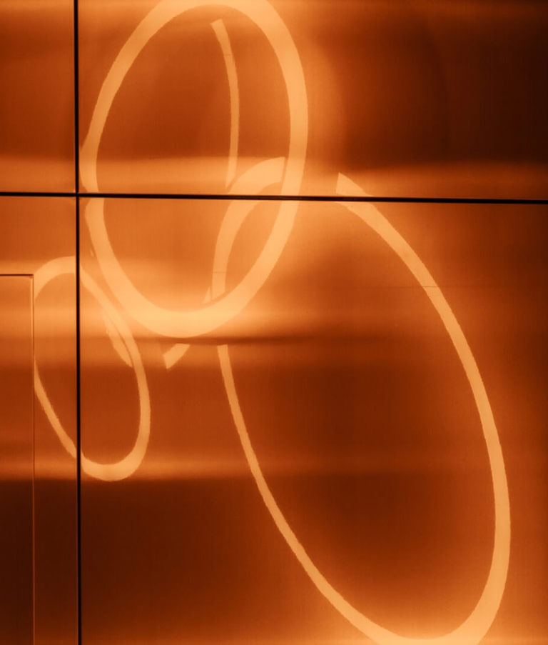 Orange light circles on a wall at the Gdansk Office in Poland. 