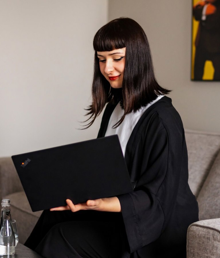 A woman working on her computer while sitting on the sofa in the Warsaw office in Poland. 