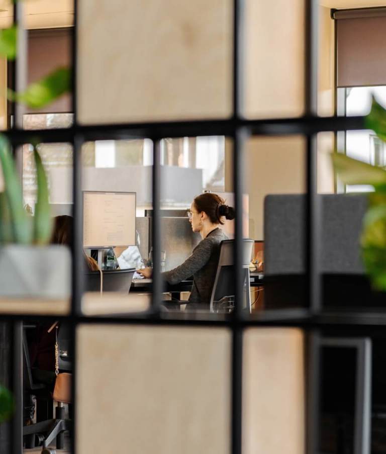 Woman working at office seen through squares in the Warsaw office in Poland. 