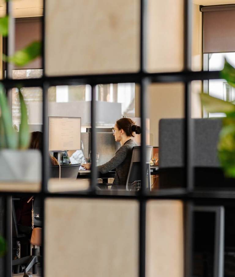 Woman working at office seen through squares in the Warsaw office in Poland. 