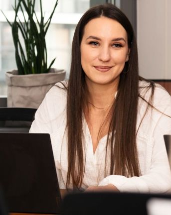 Woman at computer looking at another woman in the Warsaw office in Poland. 