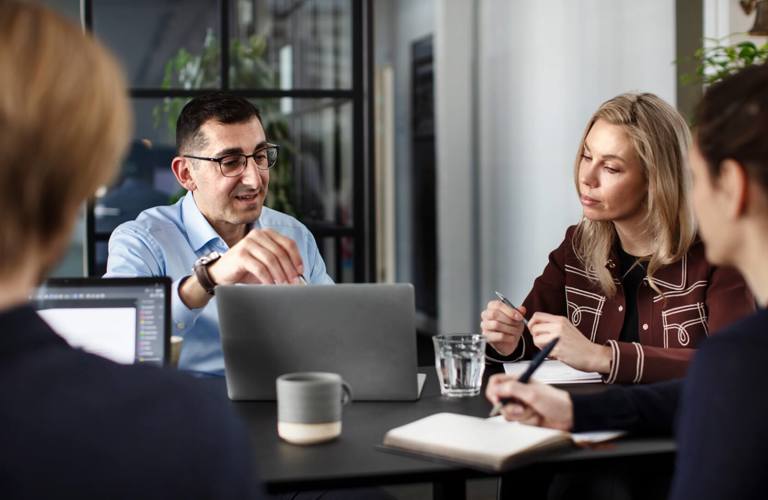 People sitting around a table in the Copenhagen office in Denmark during a meeting.